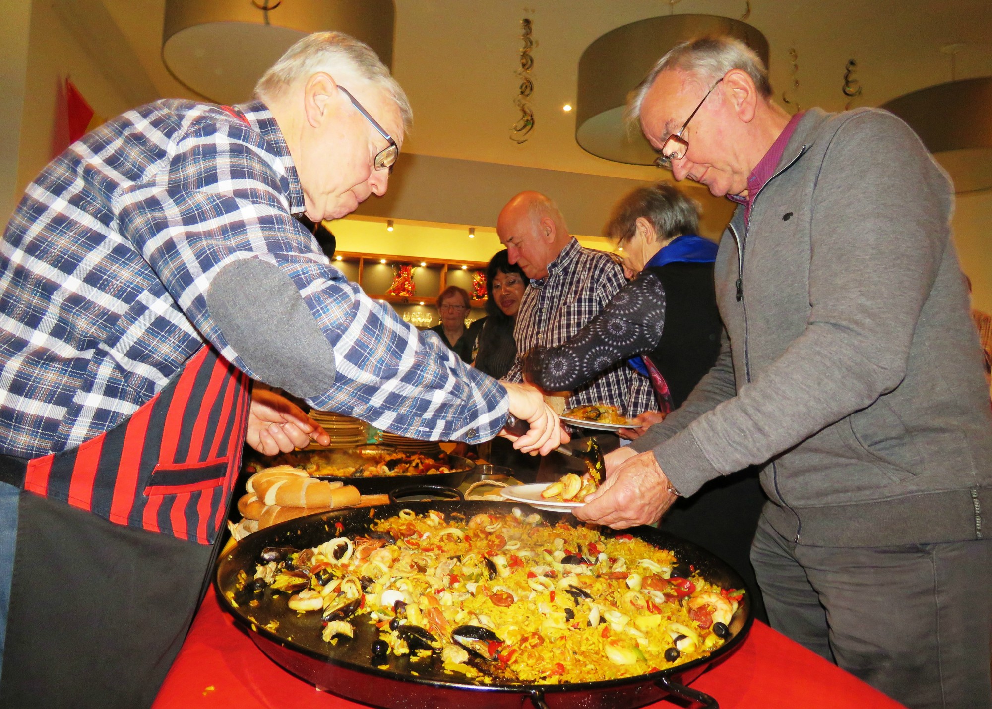 De KWB koopploeg verzorgt de lekkere paëlla