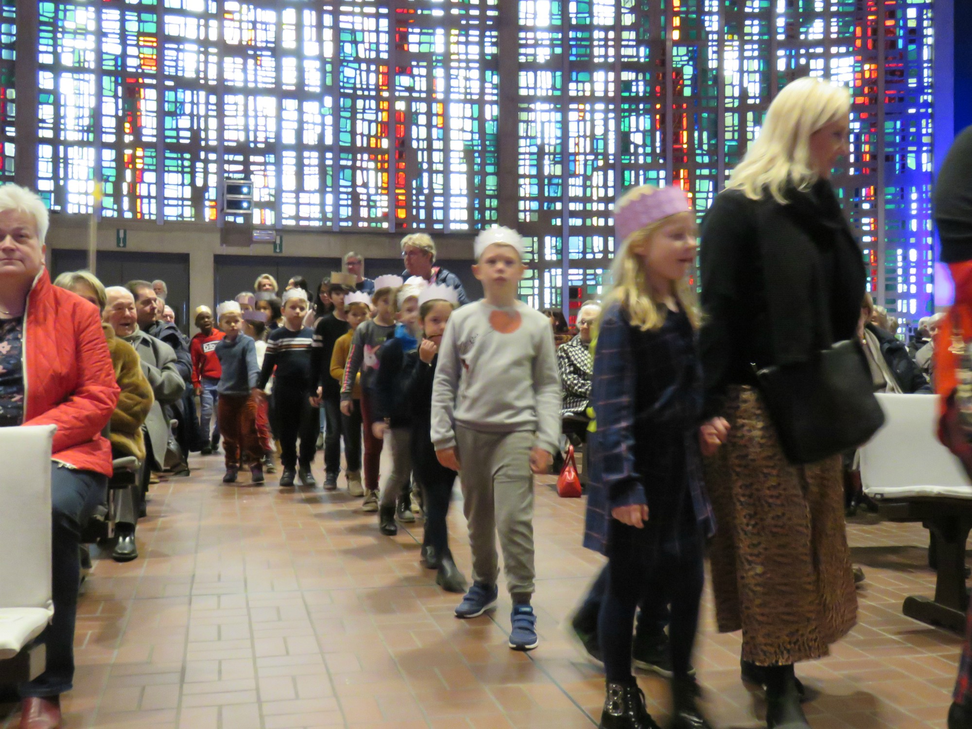Alle eerste communicanten komen met een kroon de kerk in