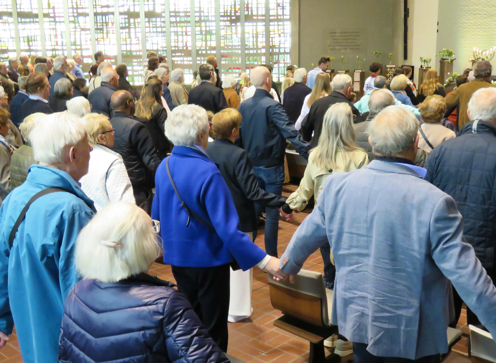 Paasviering - Het Onze Vader hand in hand over de rijen heen