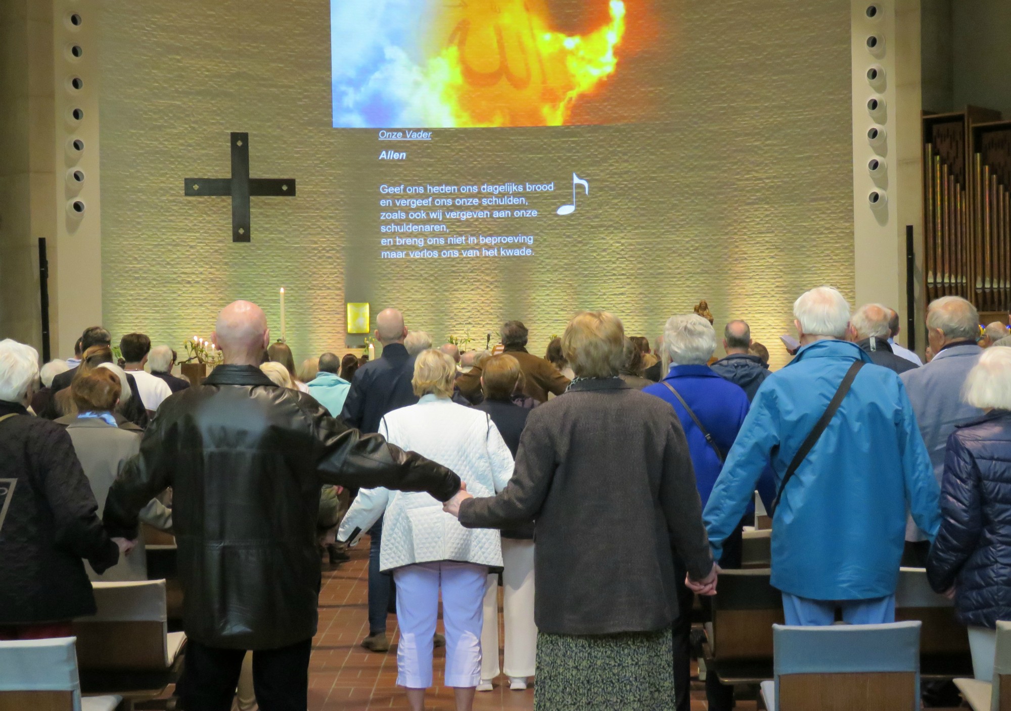Paasviering - Het Onze Vader hand in hand over de rijen heen